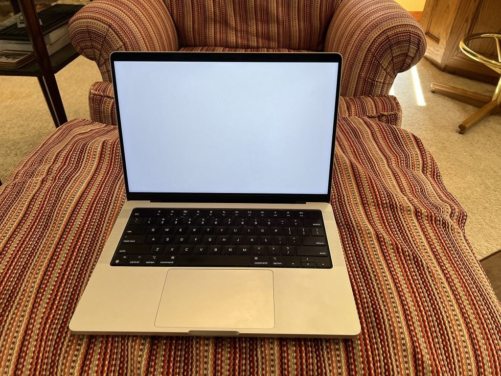 14-inch Apple MacBook Pro in silver on a sofa