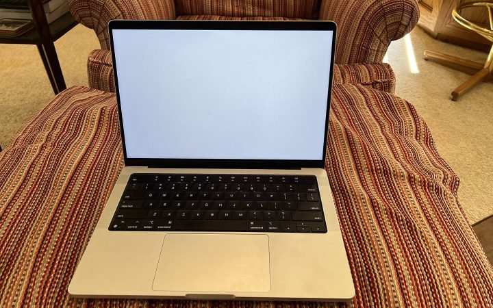 14-inch Apple MacBook Pro in silver on a sofa