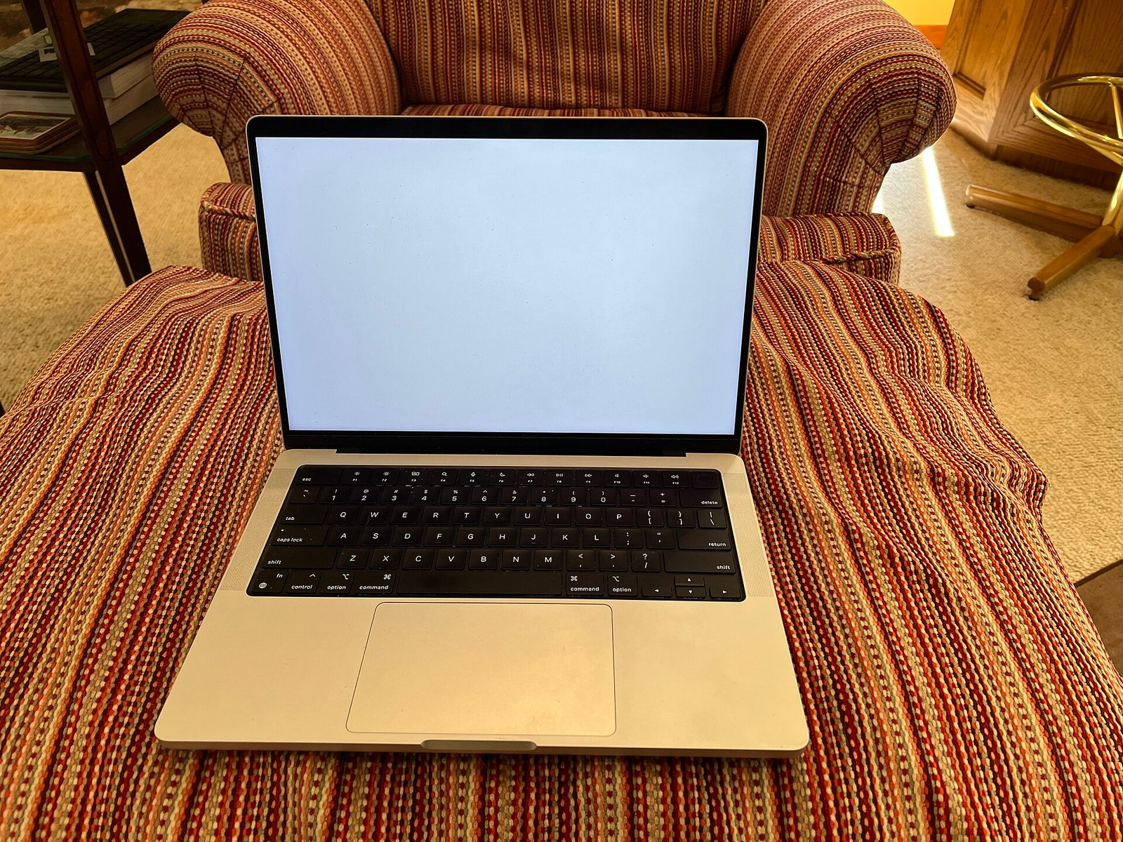 14-inch Apple MacBook Pro in silver on a sofa