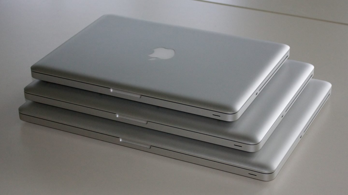 Three MacBook Pro laptops of different sizes stacked