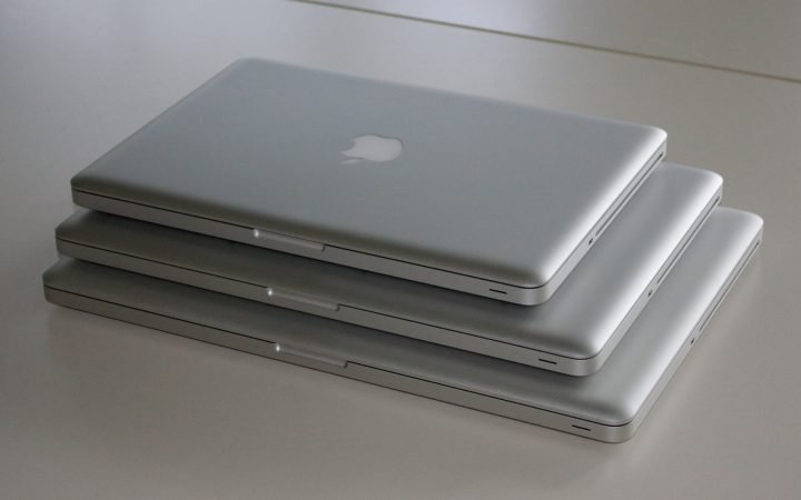 Three MacBook Pro laptops of different sizes stacked